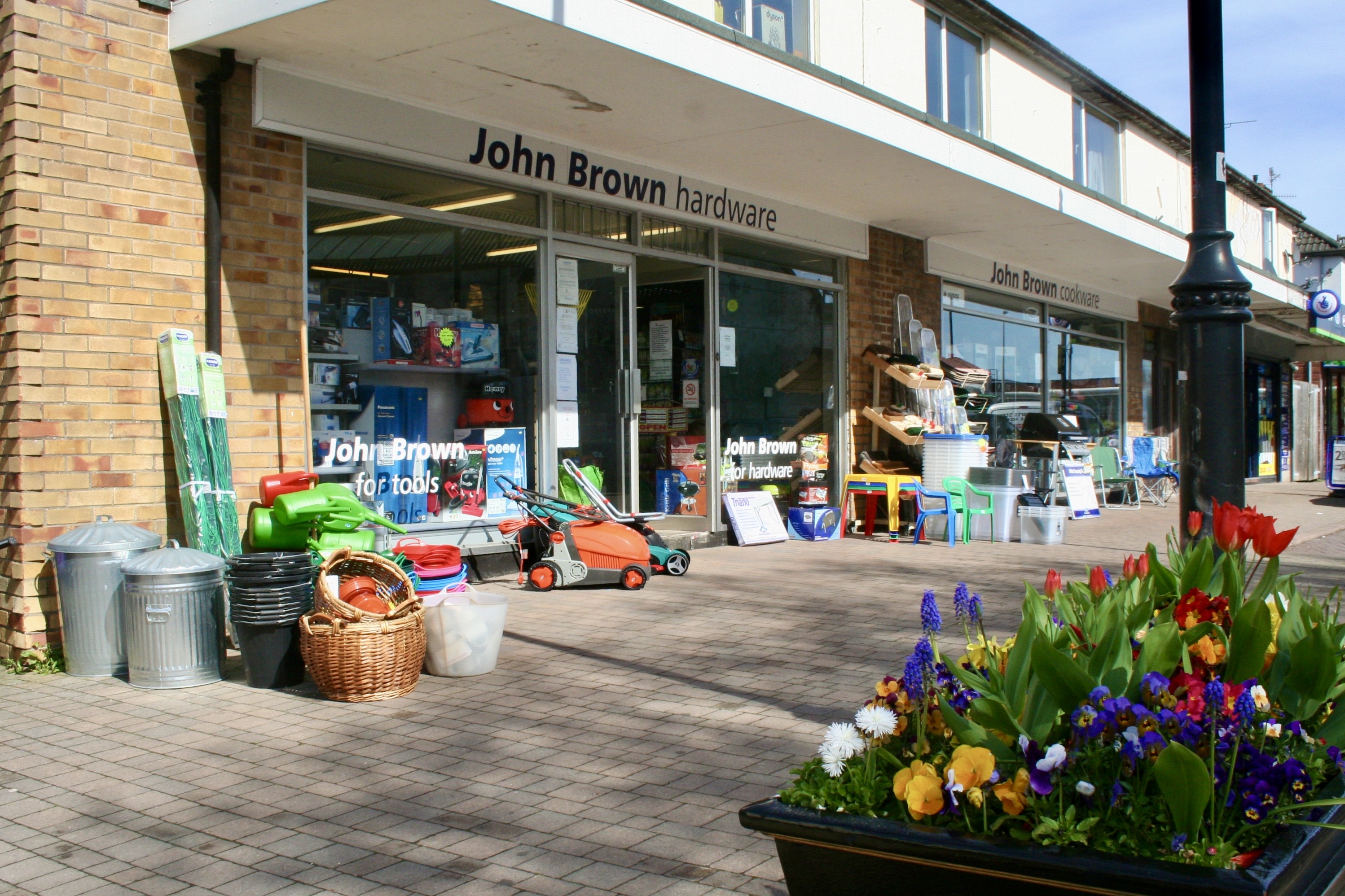 The John Brown Hardware shopfront at 90 High Street, Nailsea, with tools, garden goods and flowers displayed outside